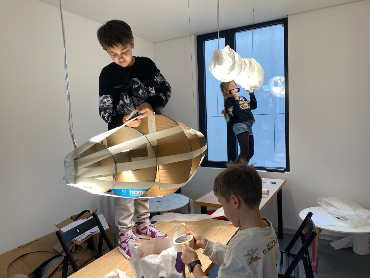 Children building cardboard objects at CheDesignSchool